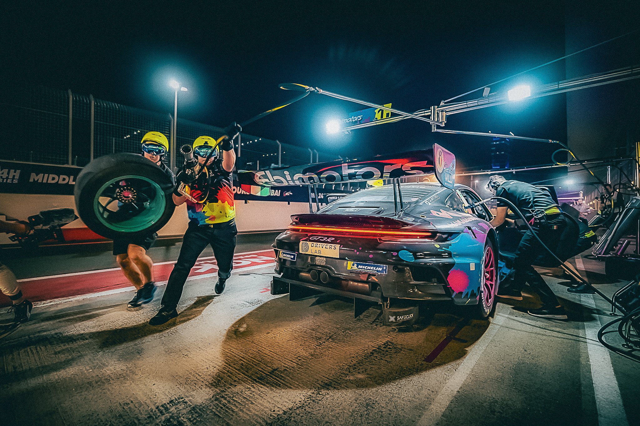 Pit crew-ul Willi Motorsport în acțiune la 24H Dubai, în timpul unei opriri de noapte pentru schimb de roți și realimentare a modelului Porsche GT3.