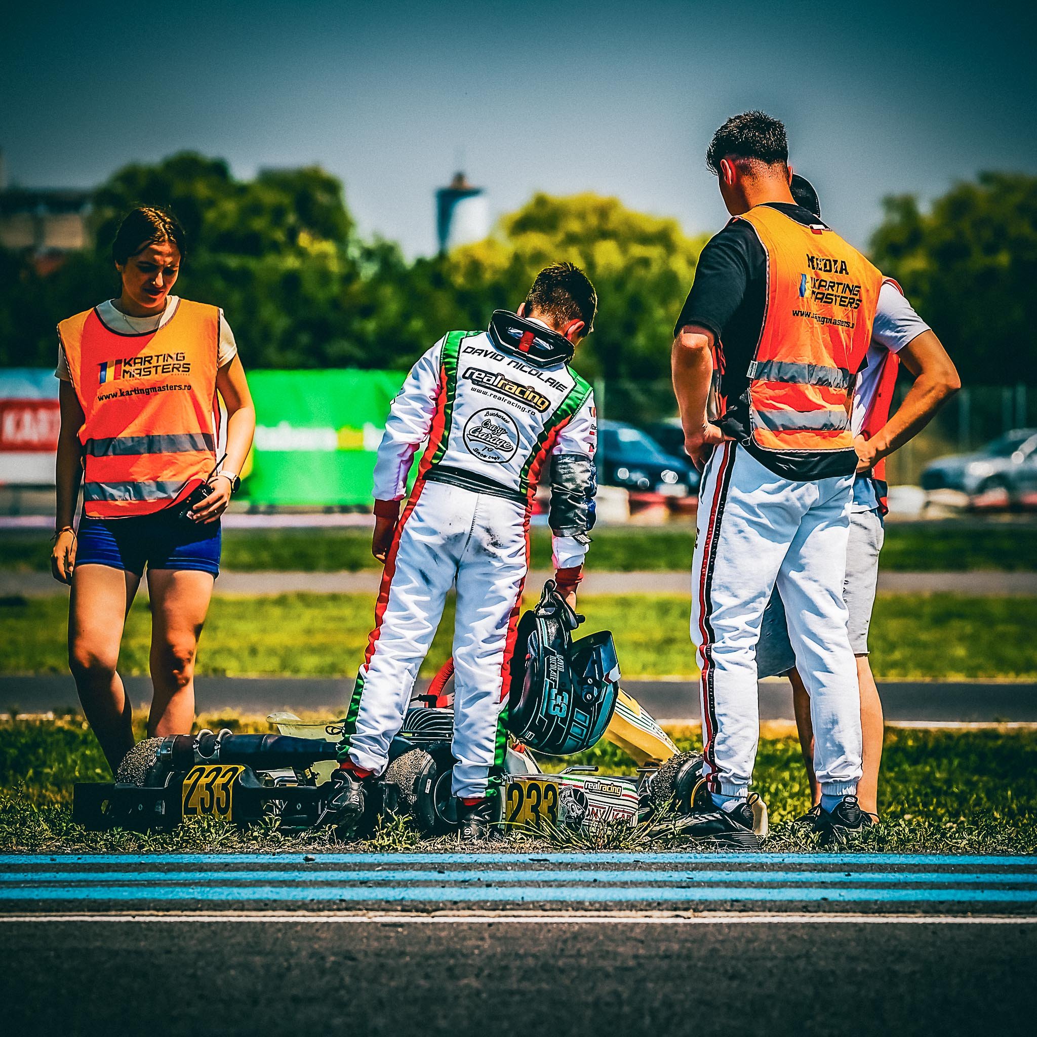 David Nicolaie lângă kartul #233, după o ieșire din cursă la Karting Masters, alături de echipă și comisari. Un moment de lecție și reflecție în cariera unui tânăr pilot.