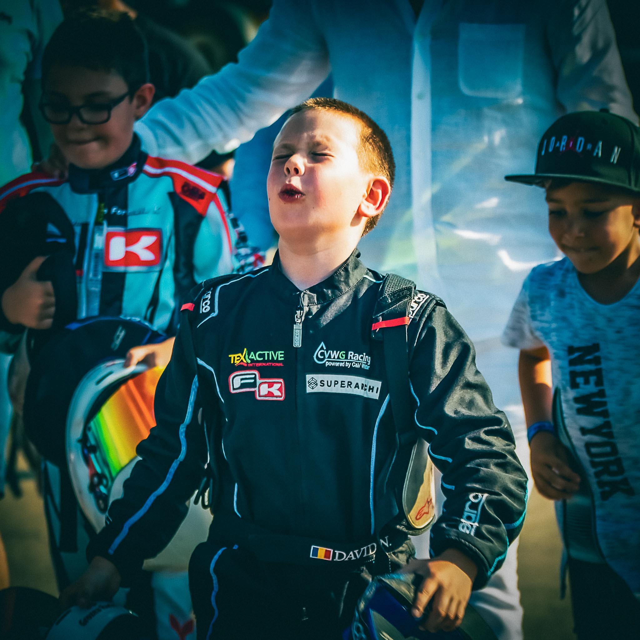 David Nicolaie, exprimând bucurie și descătușare după o cursă de karting, într-un moment sincer de emoție pură, alături de alți tineri piloți.