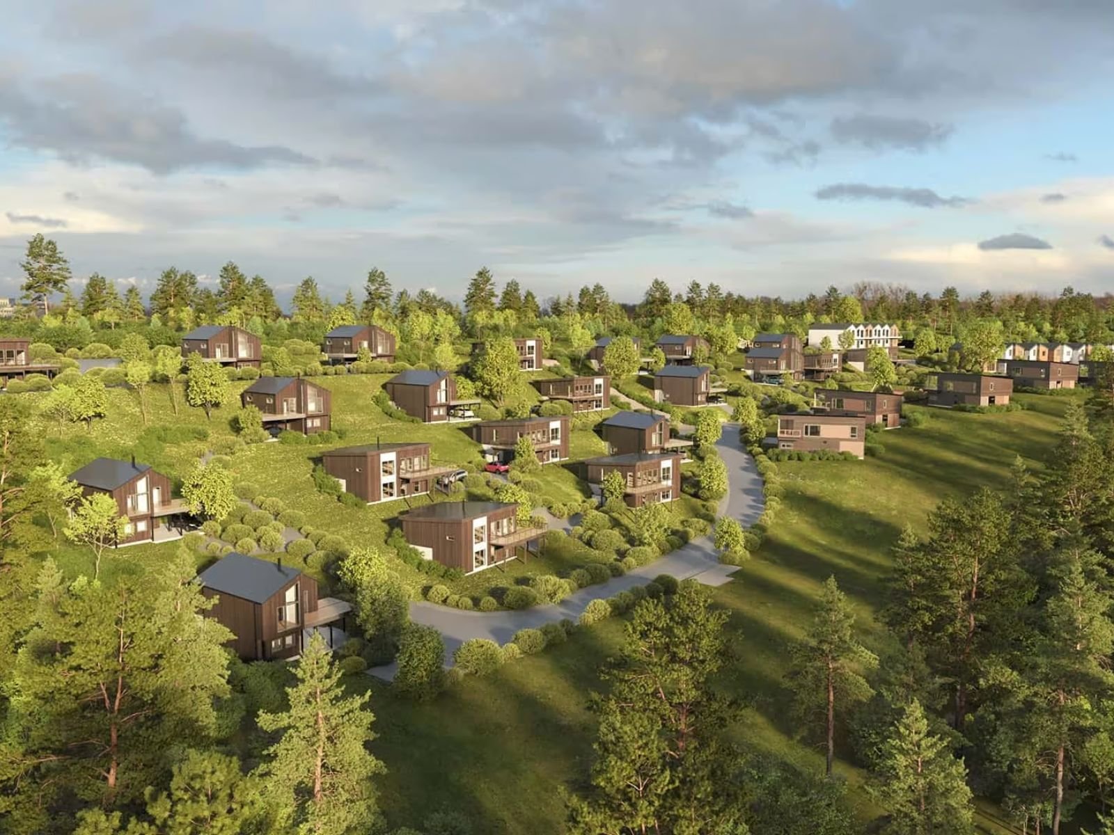 Luftbilde av et boligområde med moderne hus, omgitt av grønne trær og åser, under en overskyet himmel.