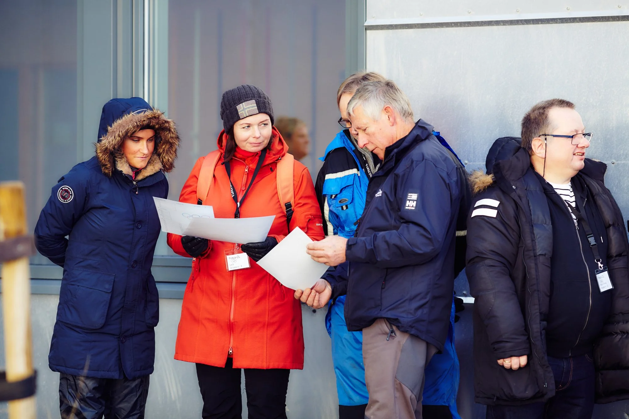 En gruppe mennesker står ute å diskuterer