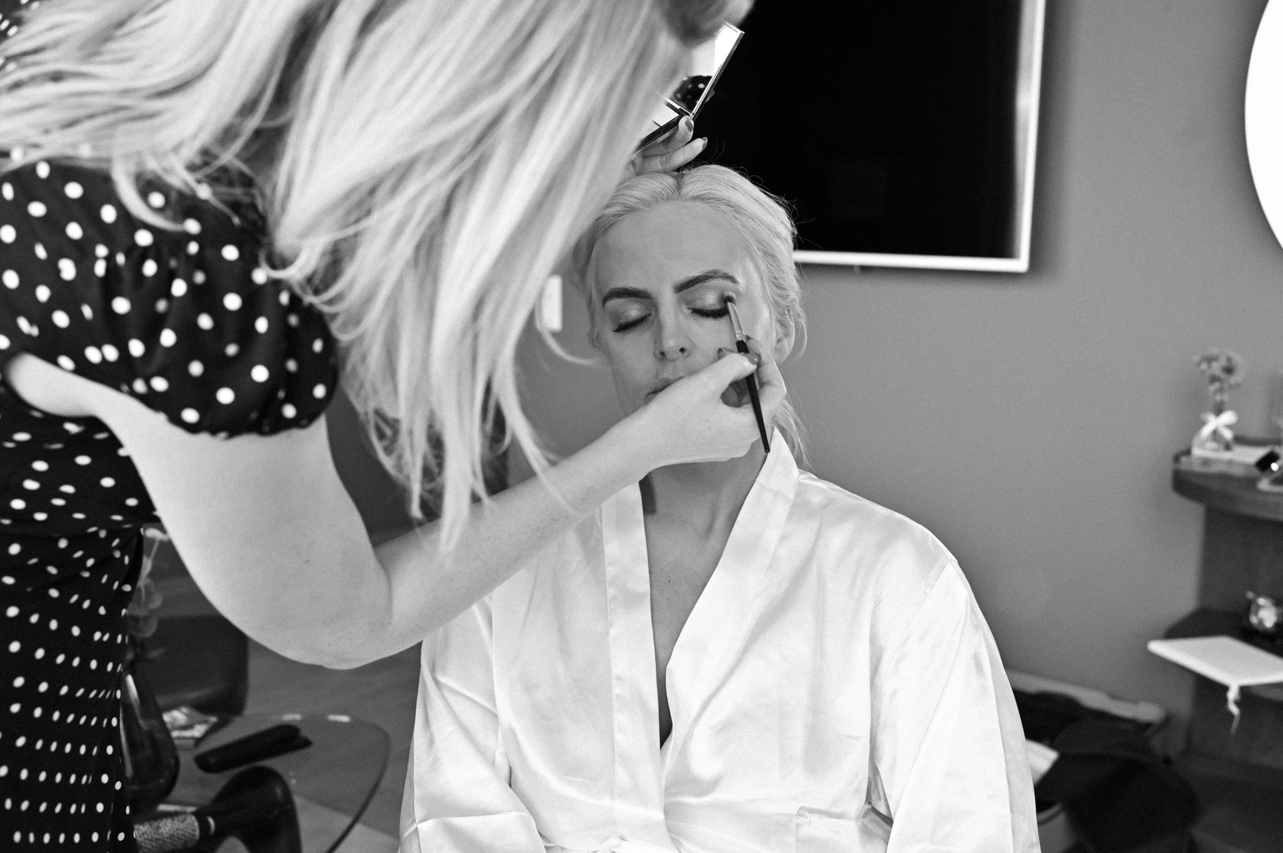 En kvinne som får makeup på øyet sitt av en makeup-artist.