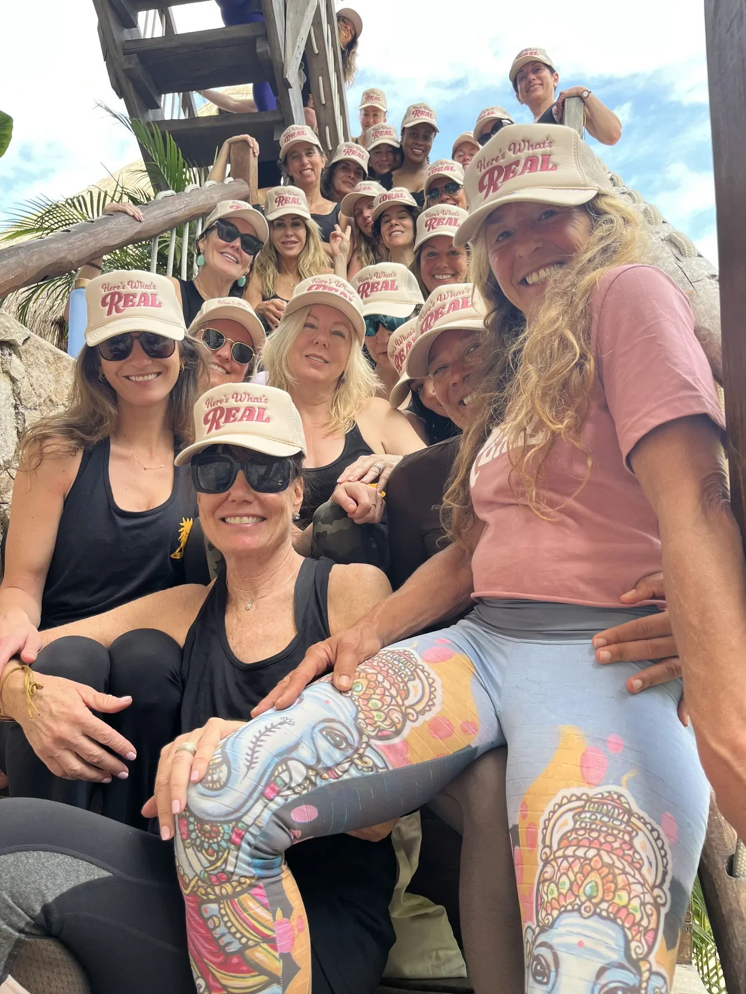 The group piled together on wooden steps in matching trucker hats.