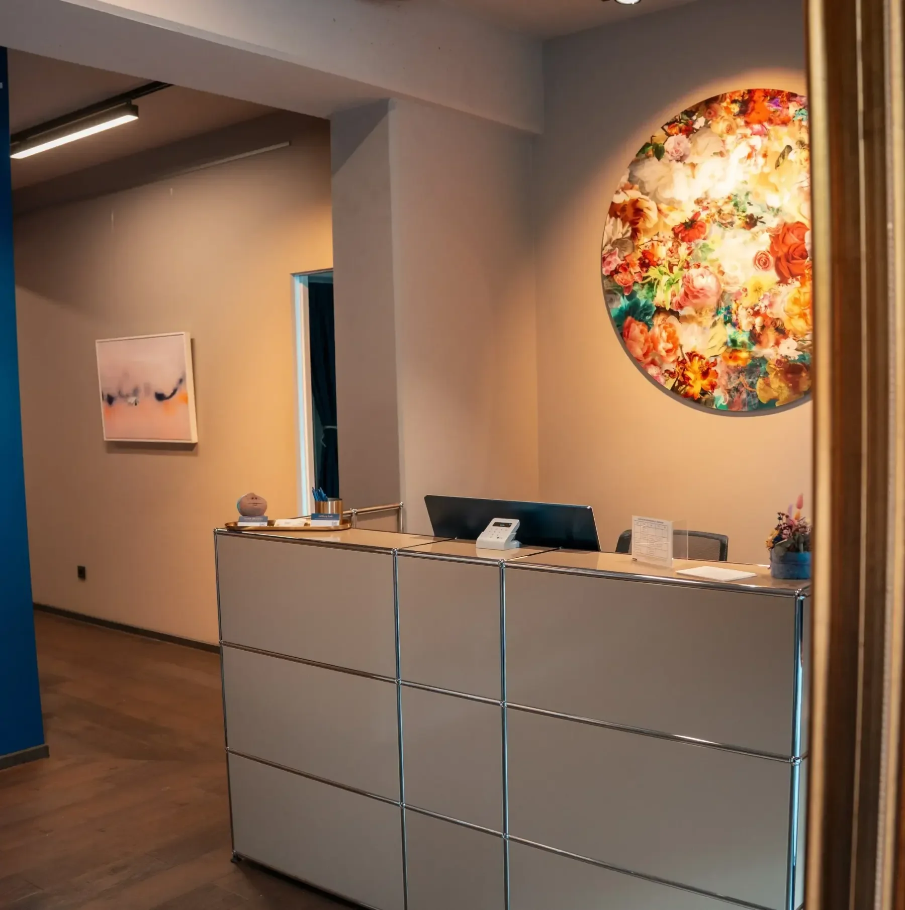Büro- oder Rezeptionstresen mit einem Computer, einem Telefon und Dekoration in der Praxis Kraftquelle Dortmund.