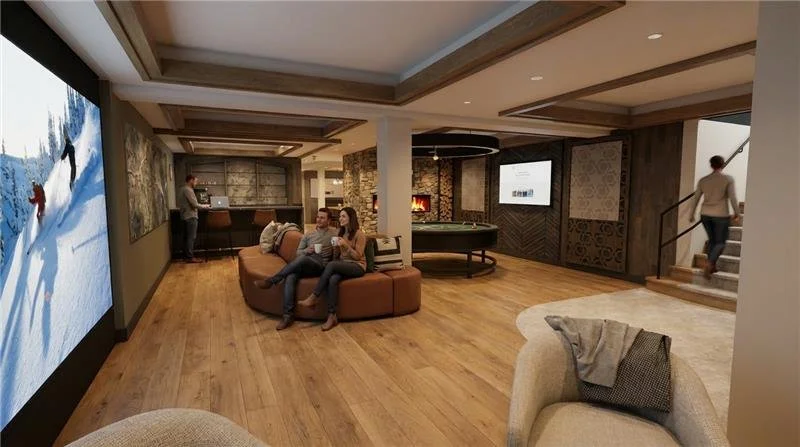 A cozy lounge area with wood flooring, a curved couch, a flat-screen TV, a fireplace, and a coffee bar. People are relaxing and socializing, and there is a staircase on the right side.