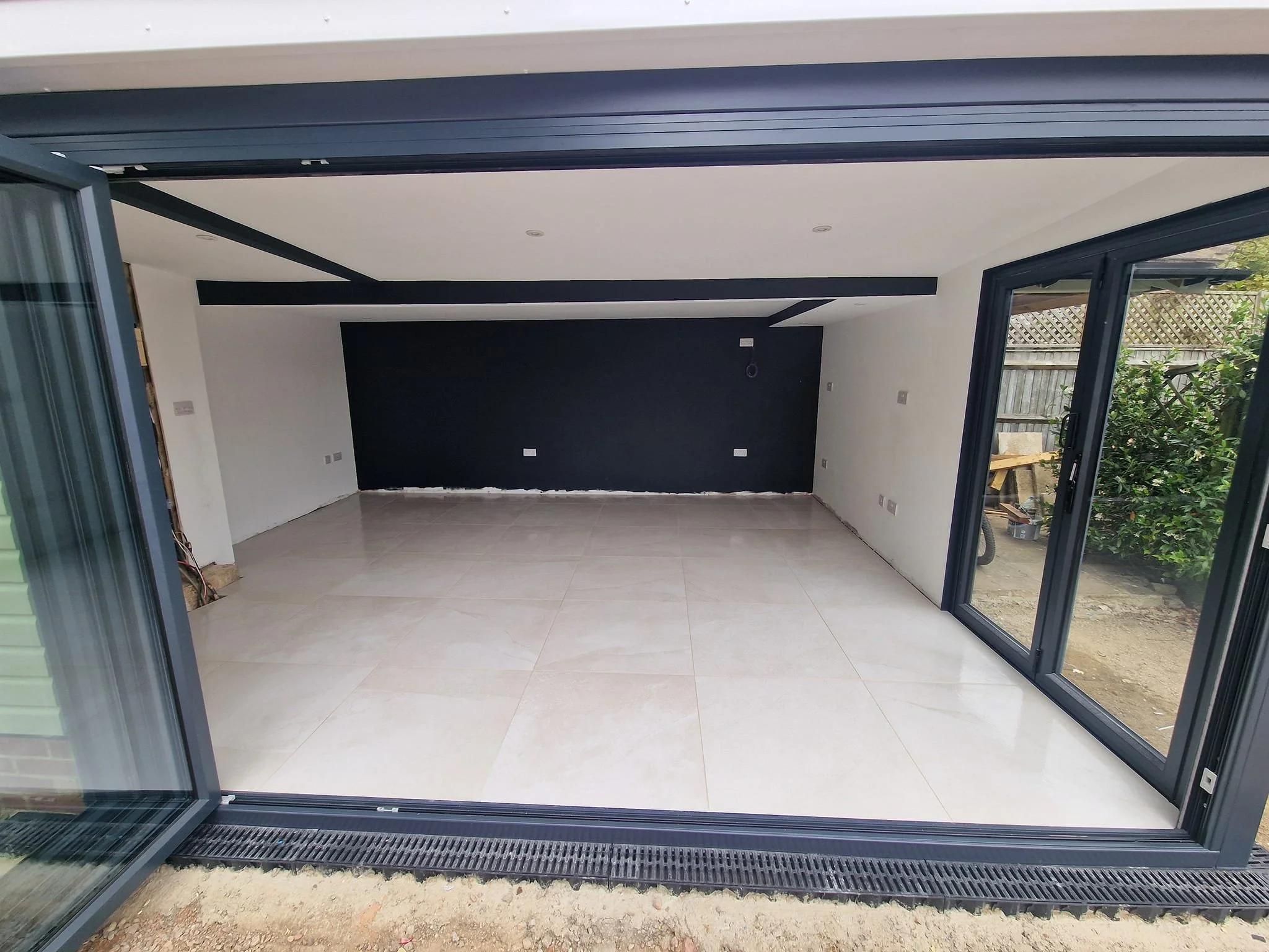 Cream large-format porcelain tiles transform this garden room into a bright, usable space year-round. hedge end tile infinity
