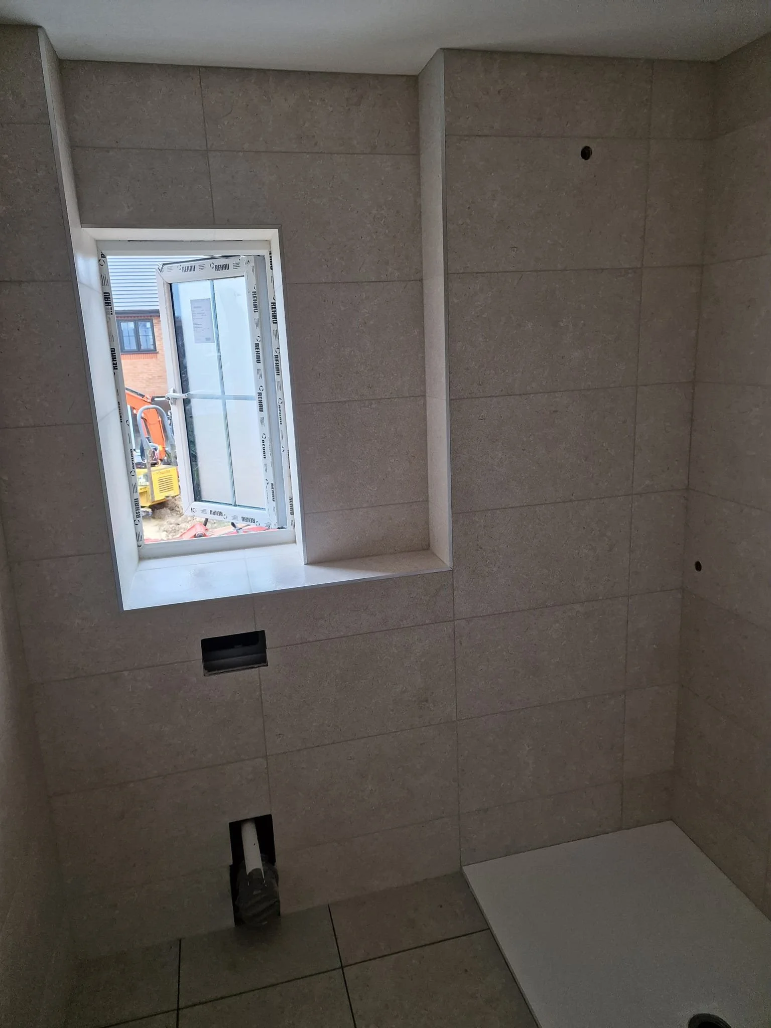 Bathroom wall and floor tiles installed in a new build home, featuring precise finishes and modern materials by professional tilers in Hampshire. Bathroom Tiling in New Build Homes