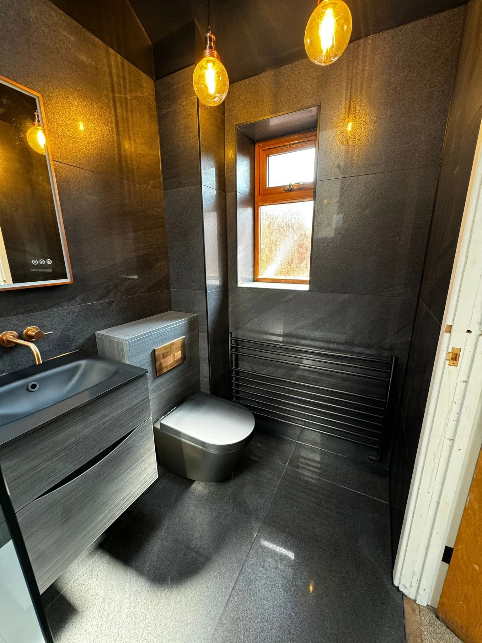 Modern black bathroom tiles installed with clean lines and a contemporary finish in a chandler's ford home, creating a sleek and stylish bathroom space.