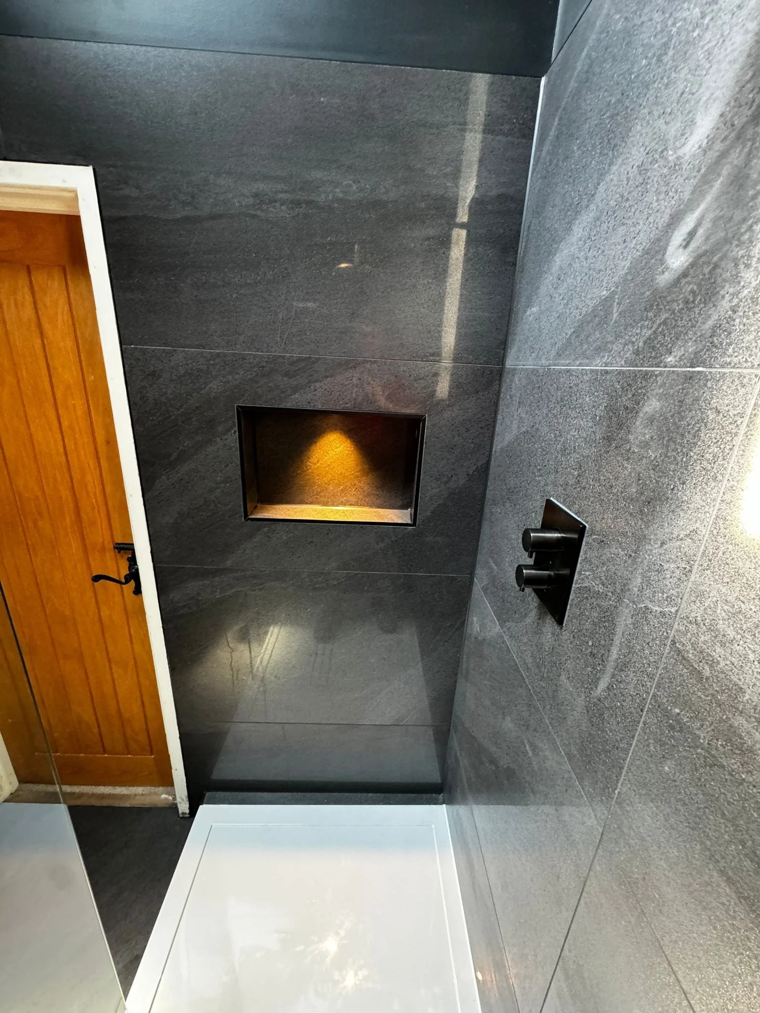Modern black bathroom tiles installed with clean lines and a contemporary finish in a Eastleigh home, creating a sleek and stylish bathroom space.