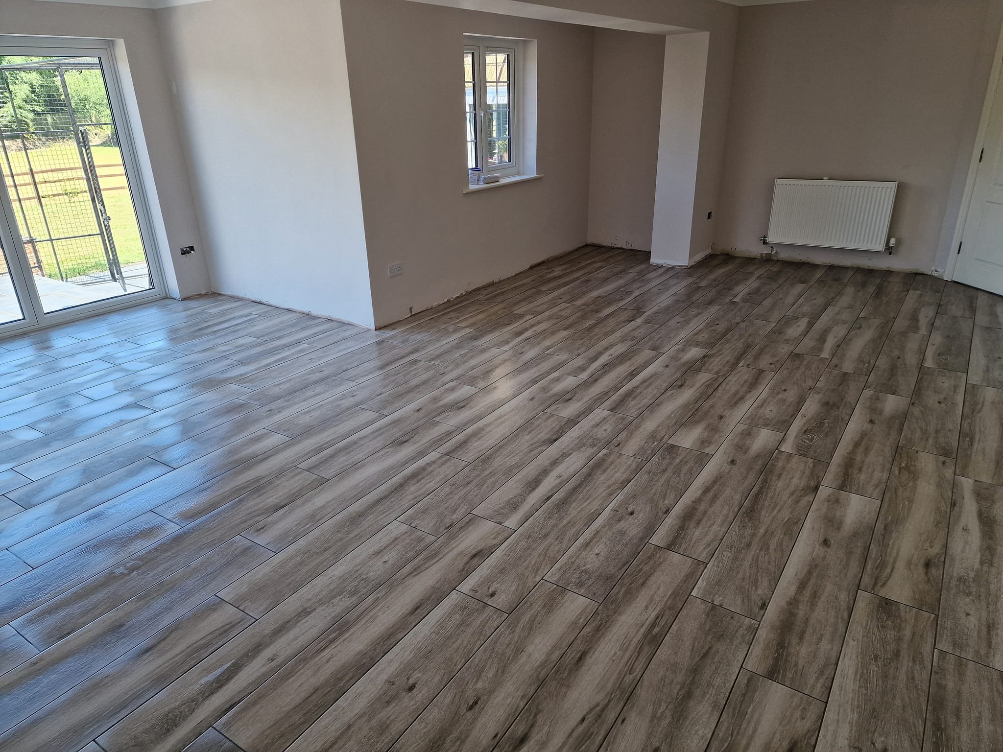 Wood Effect Floor Tiles – Eastleigh, Wood plank effect porcelain floor tiles laid continuously through kitchen, hallway and lounge, prepared with Laytex uncoupling membrane by expert floor tilers in Eastleigh, Hampshire.
