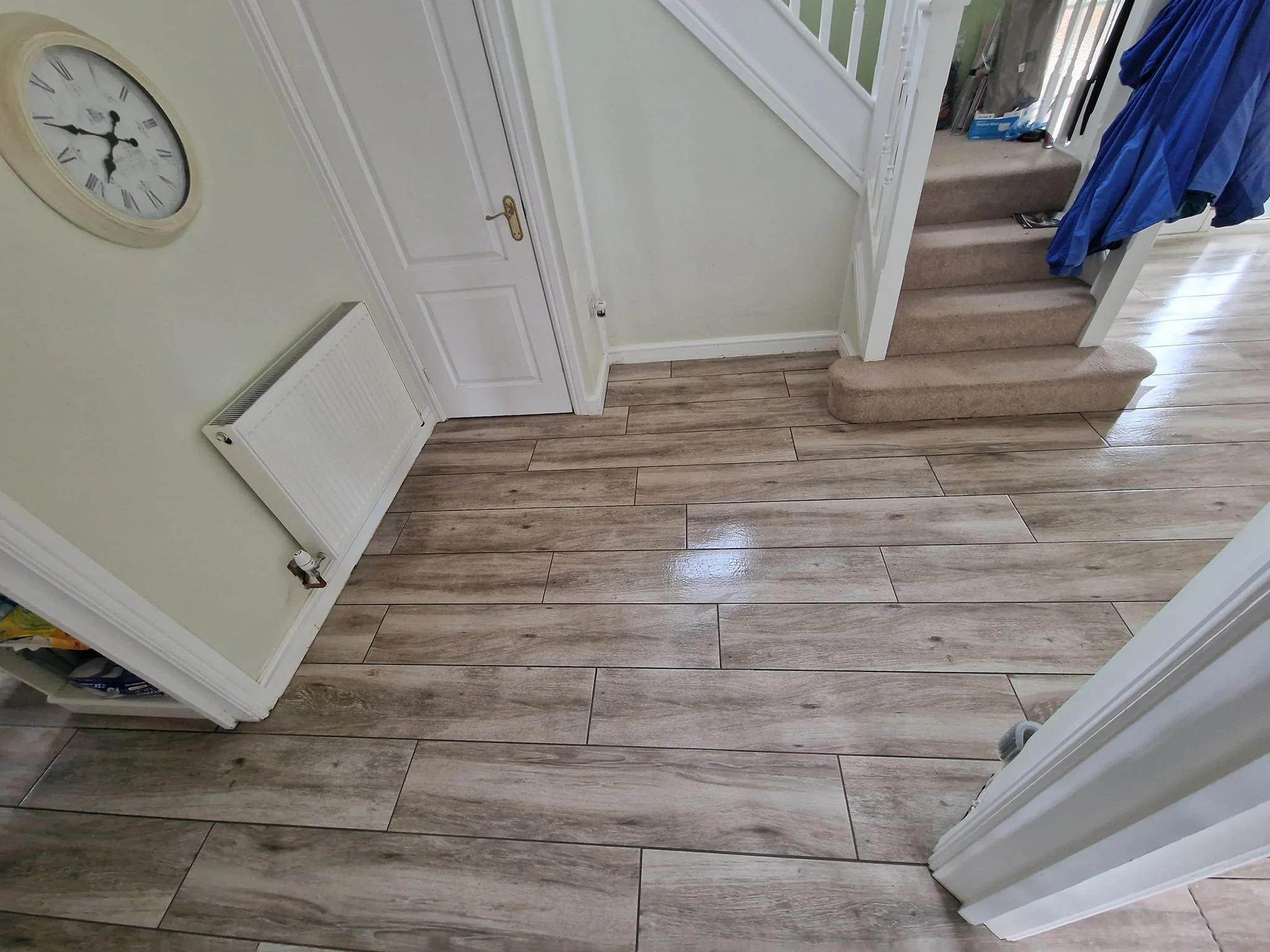 Wood plank effect porcelain floor tiles laid continuously through kitchen, hallway and lounge, prepared with Laytex uncoupling membrane by expert floor tilers in Eastleigh, Hampshire.