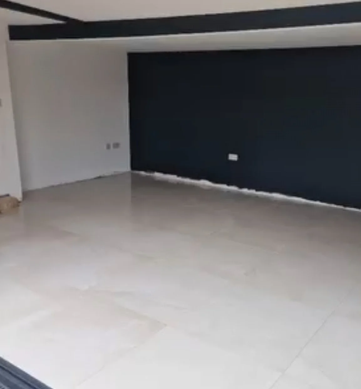 tile installation experts garden room west end southampton tile infinity local tEmpty garden room with white tiled floor, dark accent wall, and ceiling accent strip. bi-fold doors cream clean porcelain tiles tiled  by tile infinity west end Hampshire