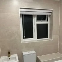 bathroom renovation showcasing newly tiled walls and floors, completely transforming the space in a Totton new forest home.