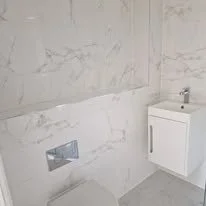 White marble effect Porcelanosa ceramic tiles fitted in a luxury new build bathroom, delivering a bright, elegant finish with the durability of ceramic in a Romsey Hampshire property.