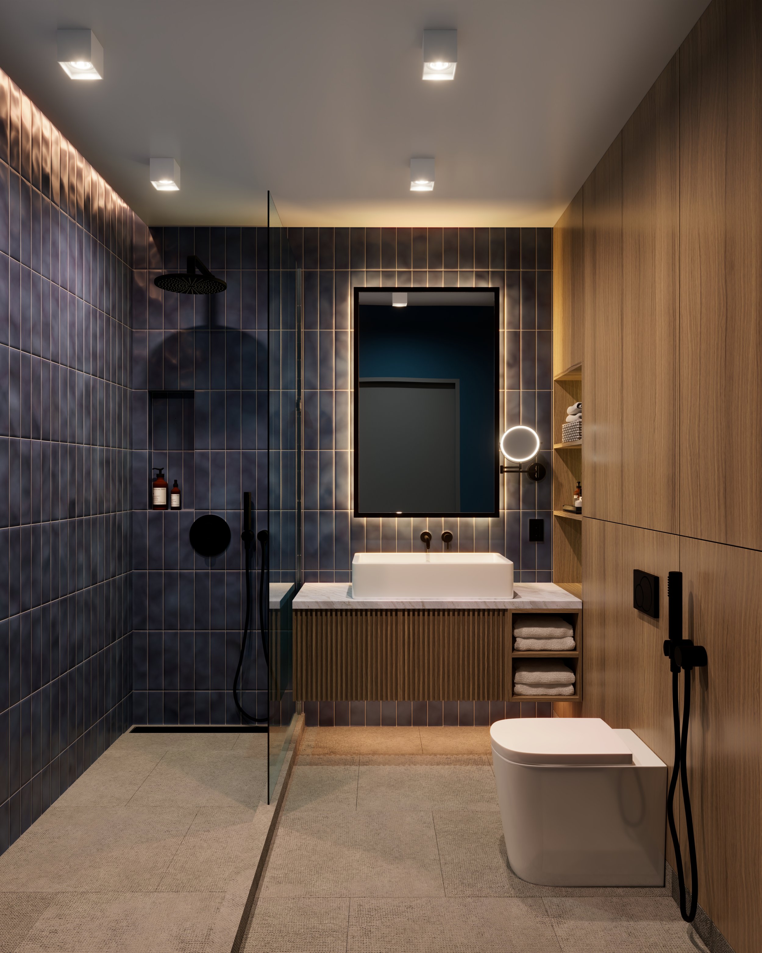 Modern bathroom with dark tiled walls, wooden cabinets, a mirror, a white vessel sink, and black fixtures. Includes a walk-in shower with a rainfall showerhead, beige floor tiles, and a small beige rug.