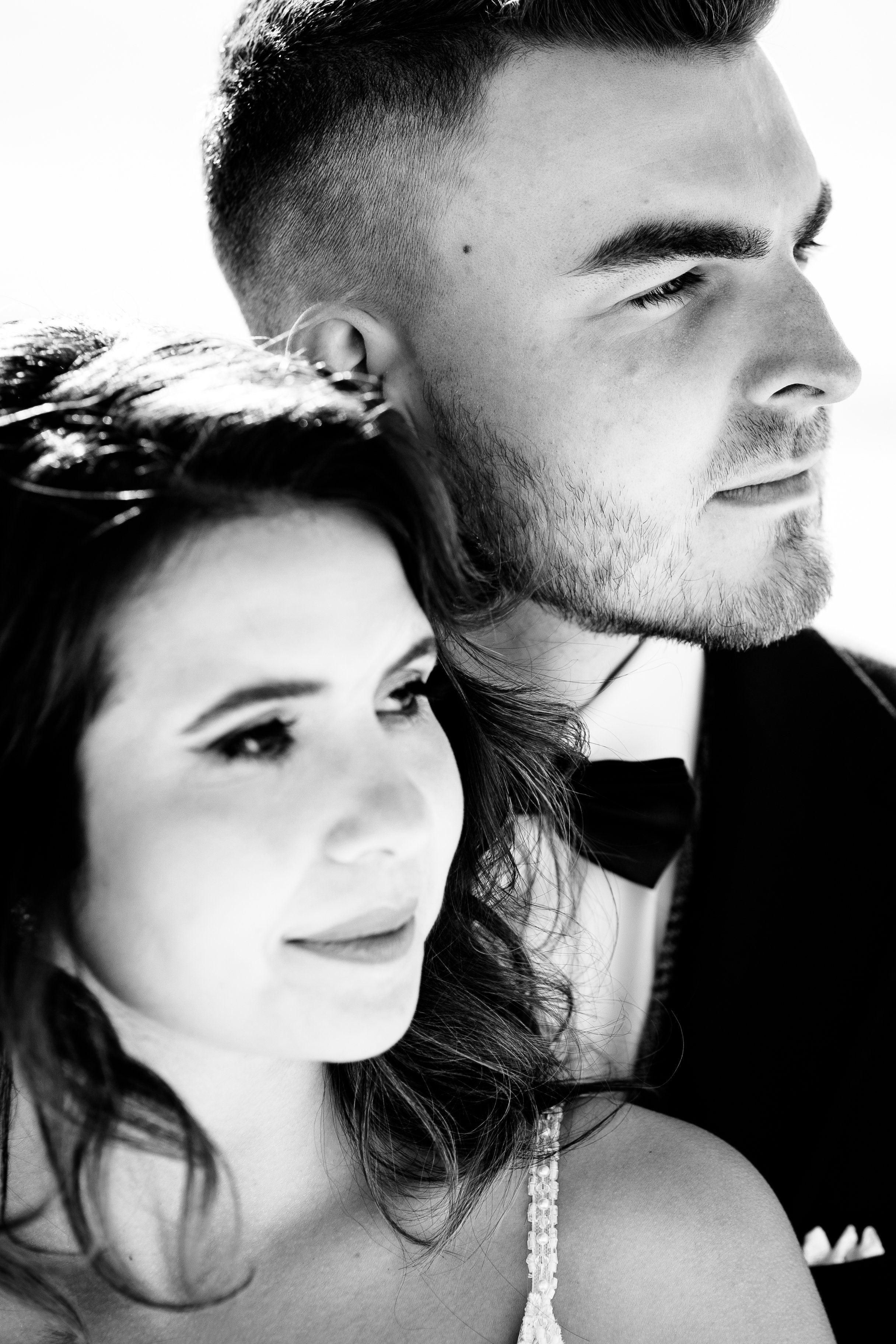 Black and white photo of a man and a woman close together, both gazing in the same direction, with serious expressions.