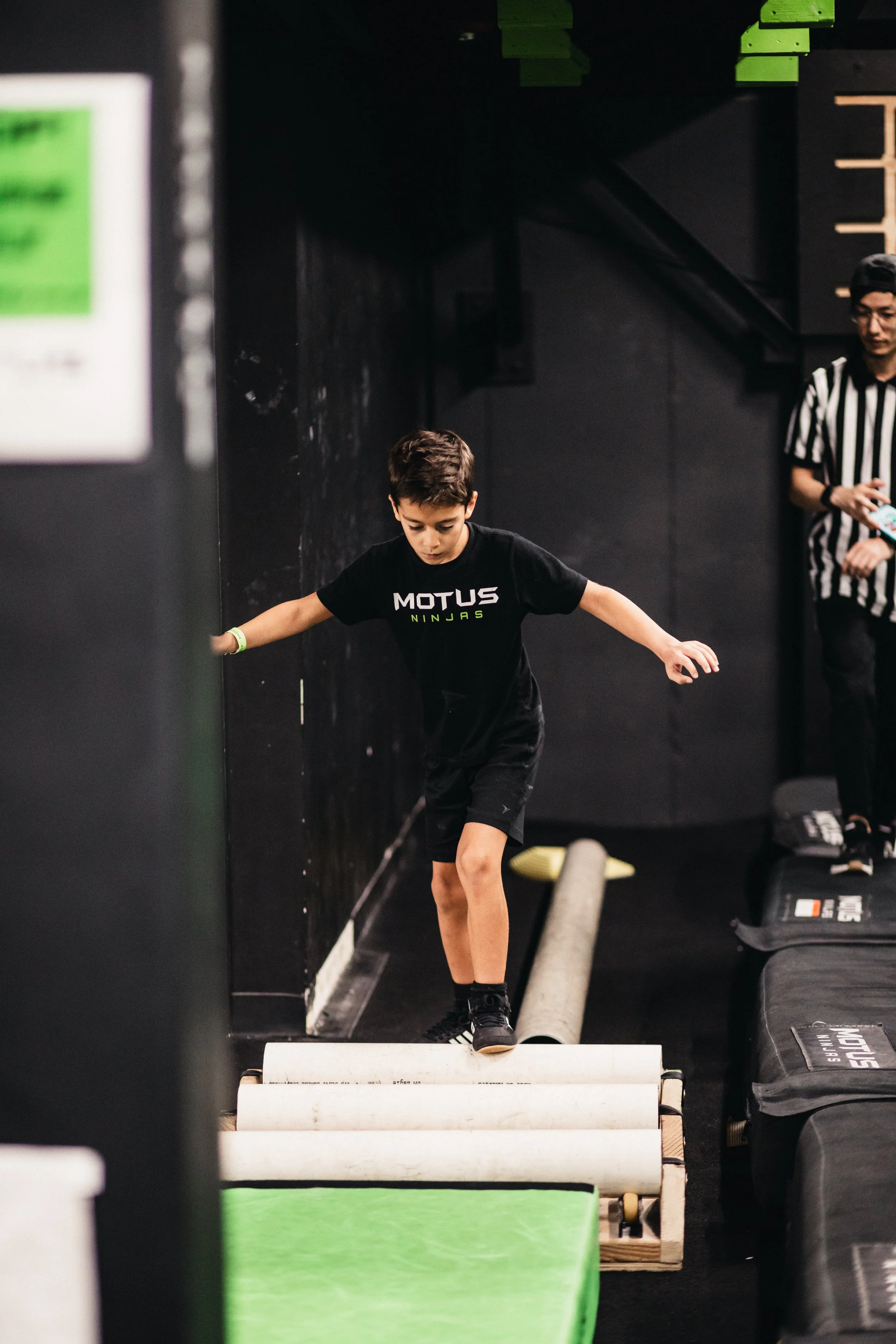Young male ninja running on obstacles at Motus Ninjas Overland Park
