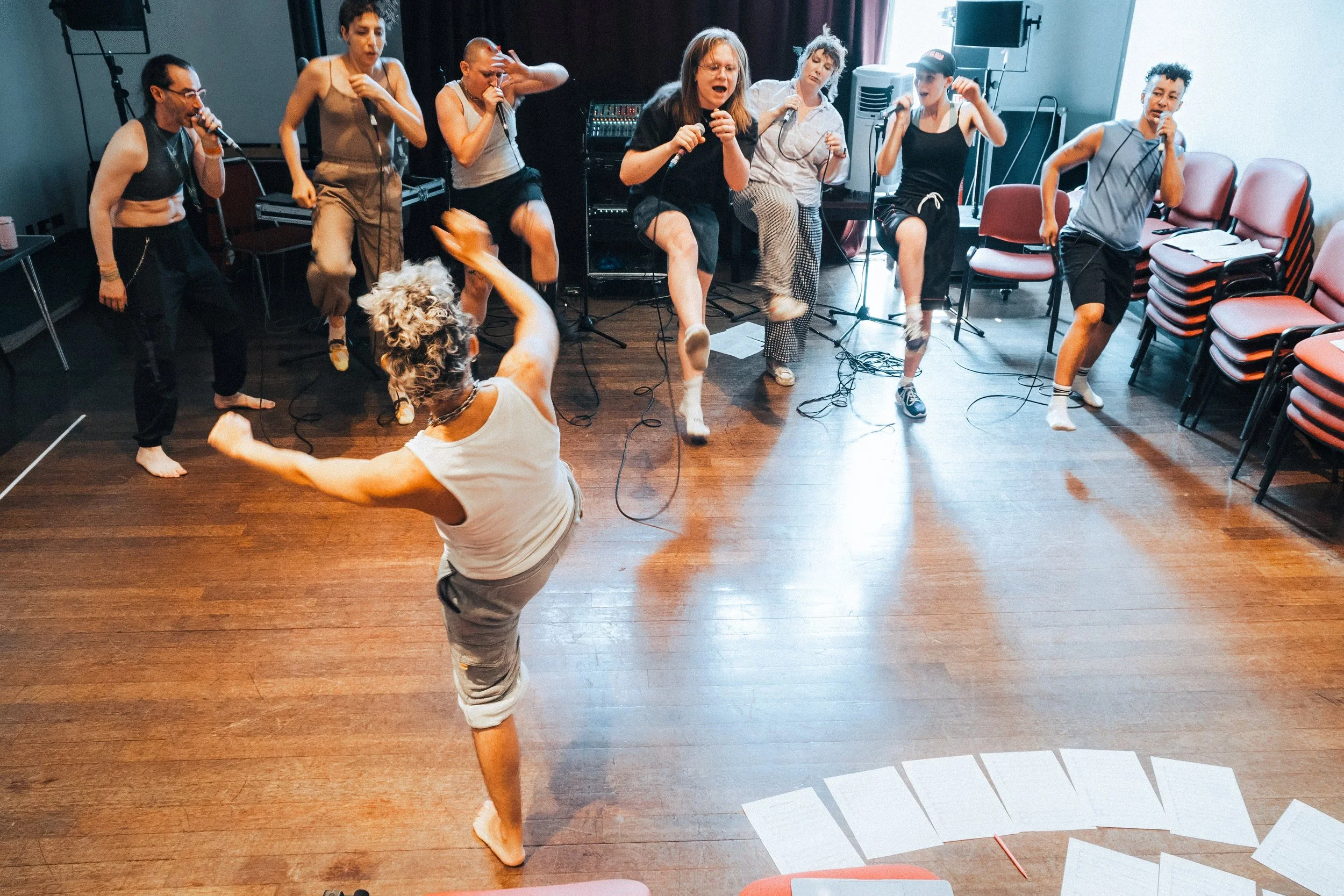A live and kicking wide shot of EM Williams movement directing SK Shlomo and the Goddexes of Beatbox Orchestra in a rehearsal room