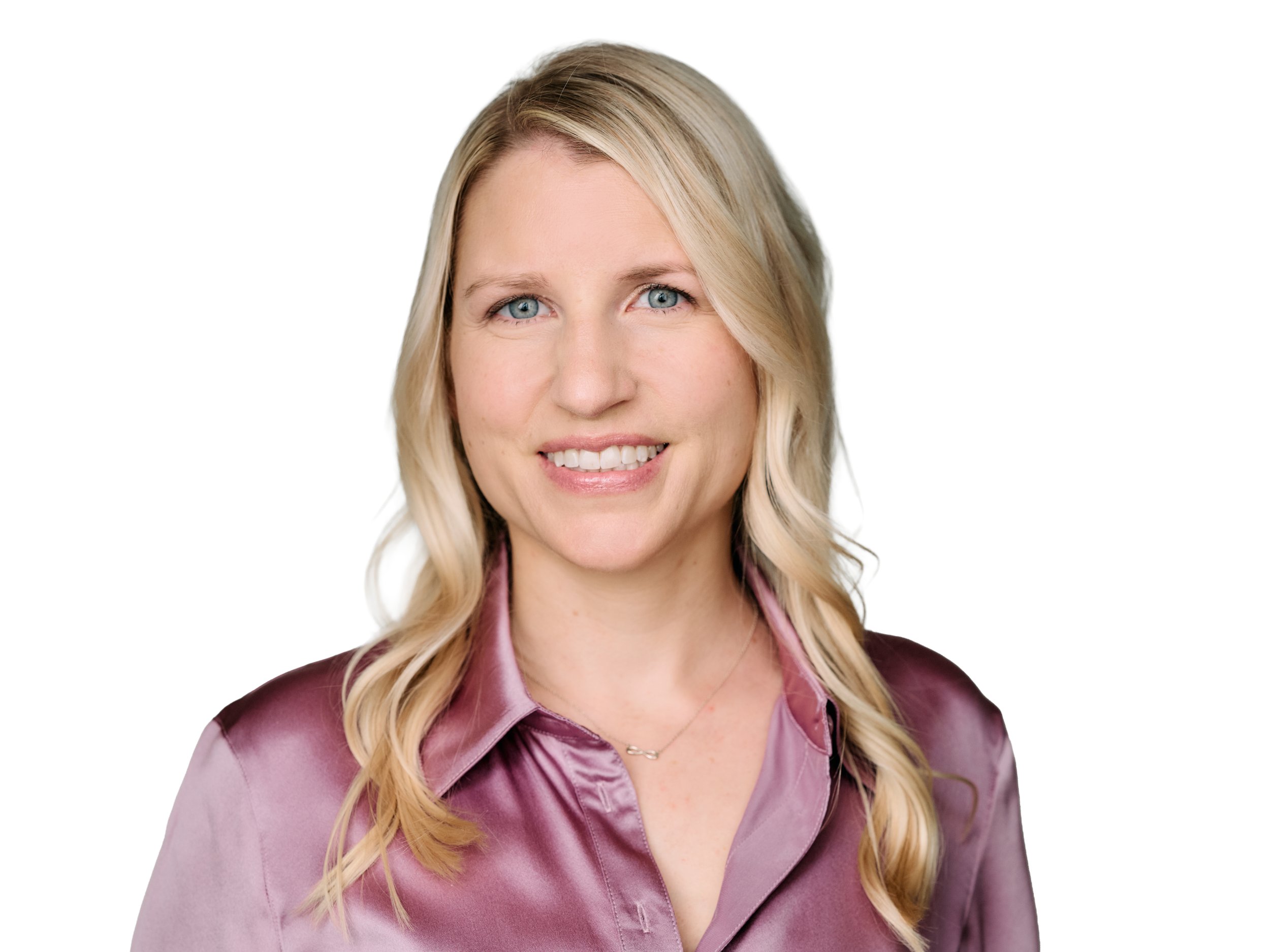 Professional headshot of a smiling woman with blonde hair, wearing a pink satin blouse and a burgundy jacket, against a plain white background.