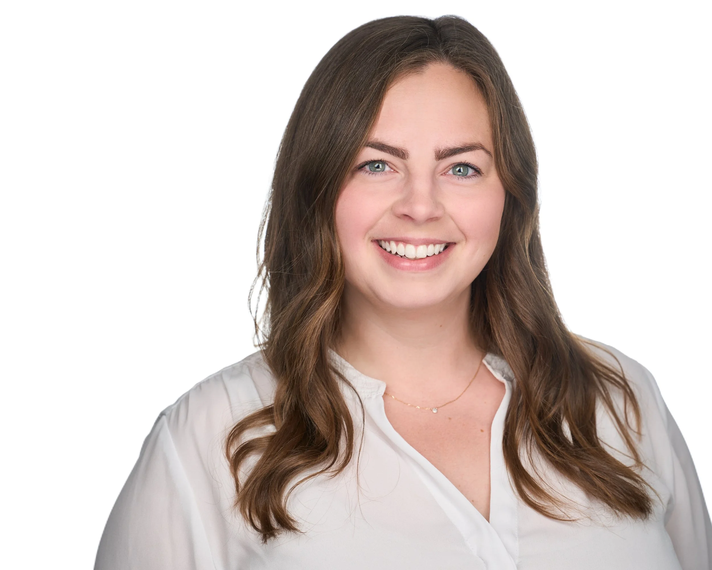 A young woman with long, wavy brown hair, blue eyes, and a friendly smile, wearing a white blouse and a delicate gold necklace, against a plain white background.