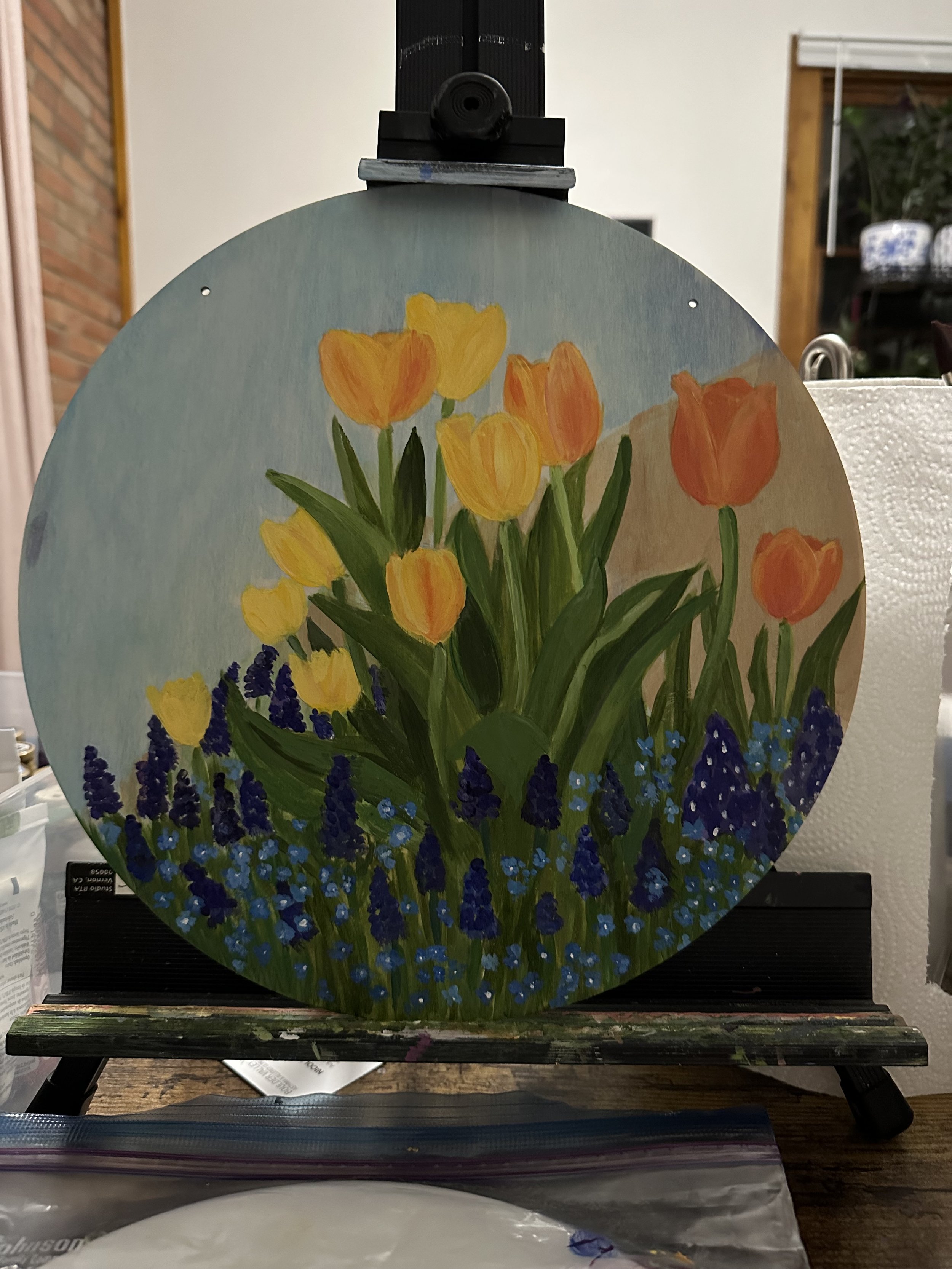 Tulips and bluebells on wooden round