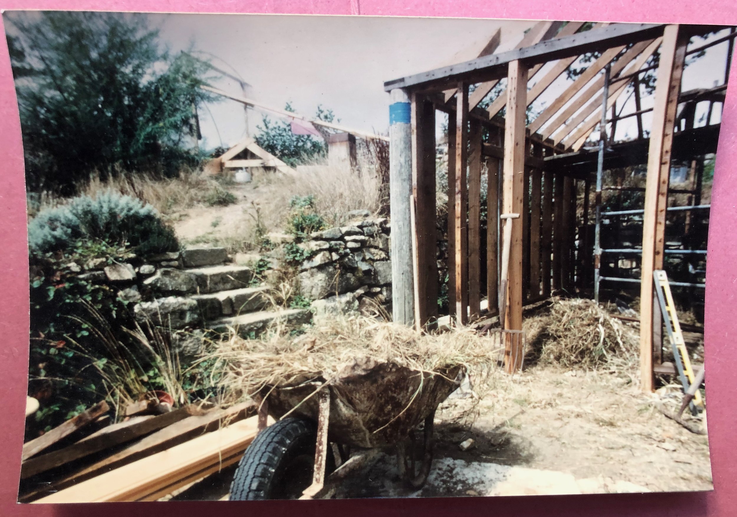 Office building in progress, using mainly wood, and a wheelbarrow of hay for the goats.