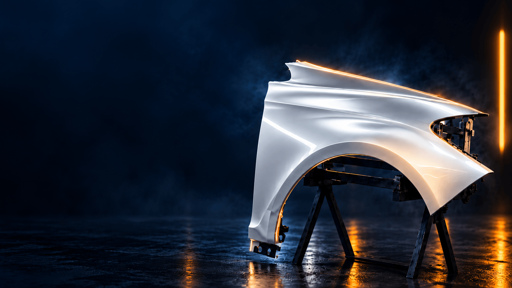 A sleek, futuristic car fender illuminated by lights in a dark environment, mounted on a stand.