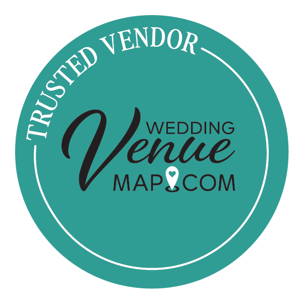 A circular teal logo for Wedding Venue Map Dot Com with white text stating "Trusted Vendor" along the top edge, and black cursive text in the center that says "Venue" with smaller black text around it reading "Wedding" and "Map Dot Com". There is a white location pin with a heart inside it below the word "Venue."