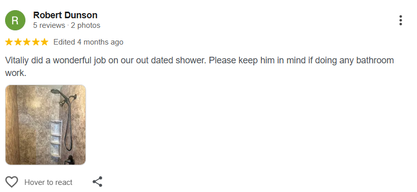 Shower with a wall-mounted showerhead, a shower caddy with shelves, and textured beige wall tiles.