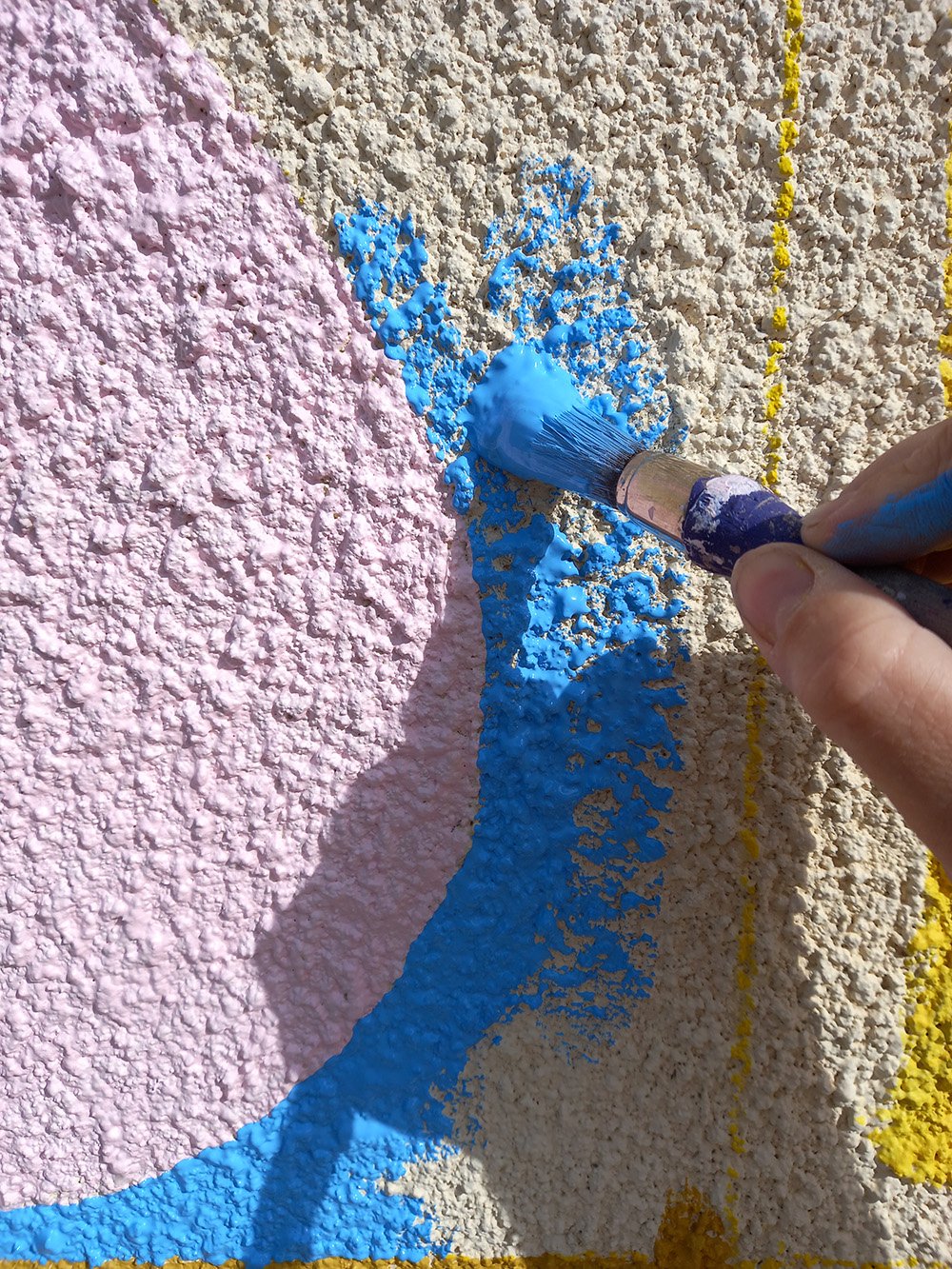 A close up of a brush painting on pebbledash