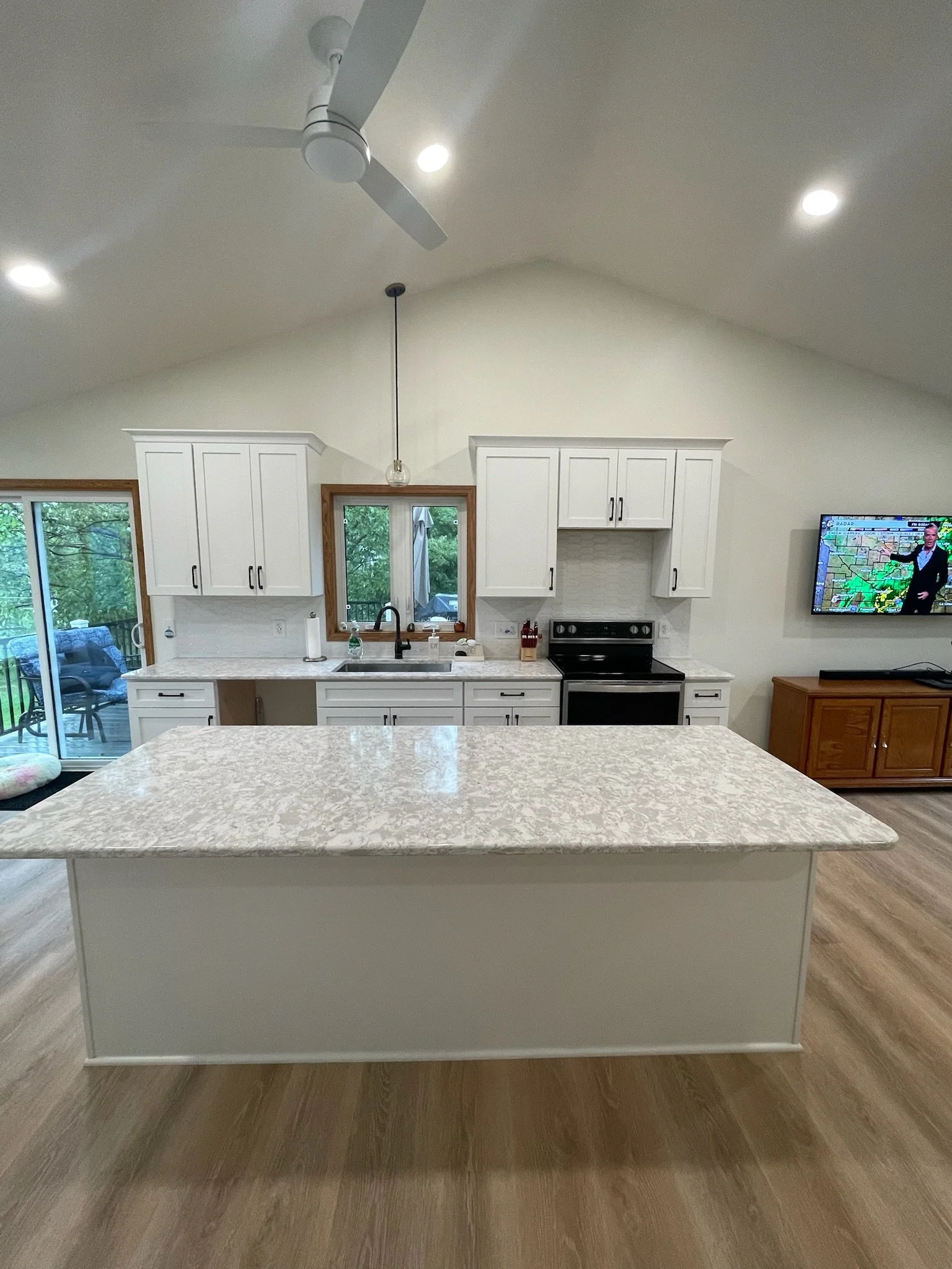 Bright open concept kitchen remodel in Minnesota featuring white cabinets and quartz counters