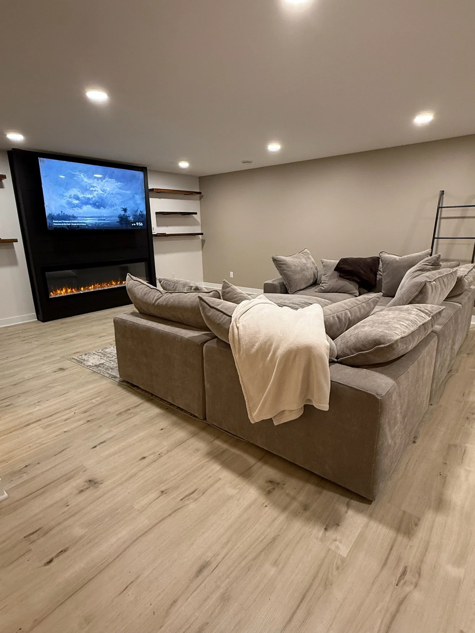 Cambridge MN basement remodel with electric fireplace, vinyl plank flooring and floating shelves