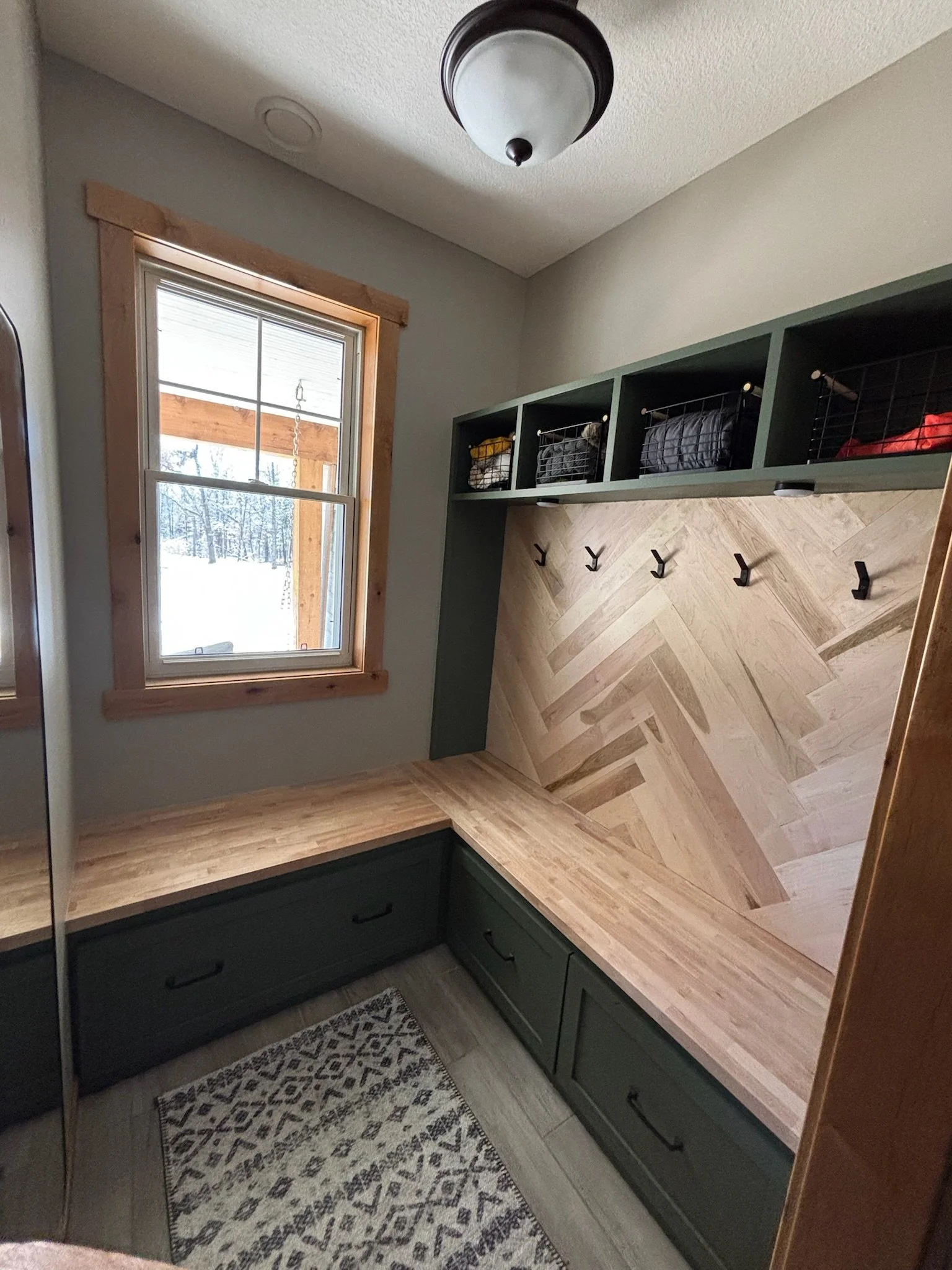 Minnesota mudroom with bench seating, wood countertops, and built-in storage cabinets