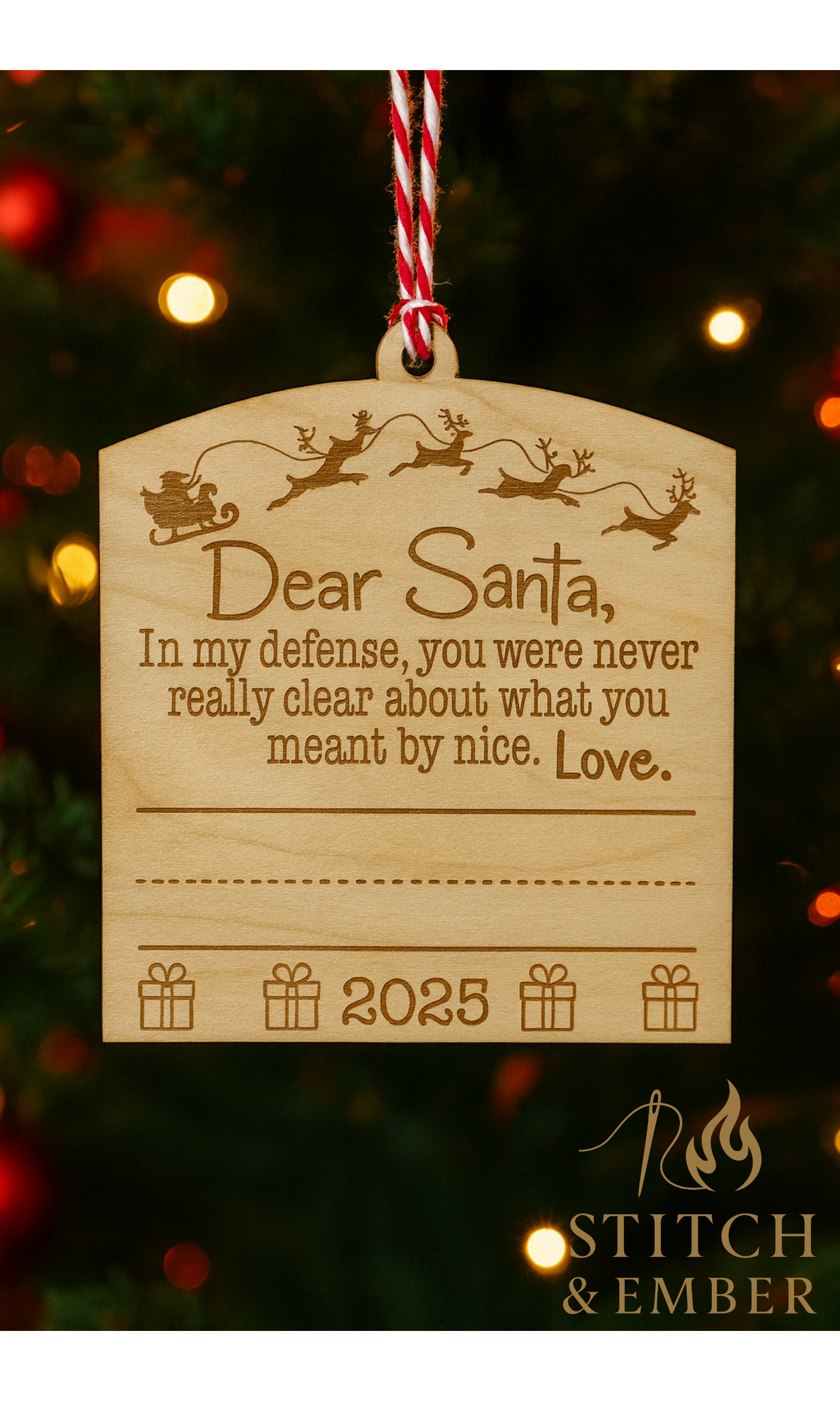 Wooden Christmas ornament with Santa's sleigh and reindeer graphic, holding a humorous handwritten message to Santa, with the year 2025 and gift box icons, hanging on a decorated Christmas tree.