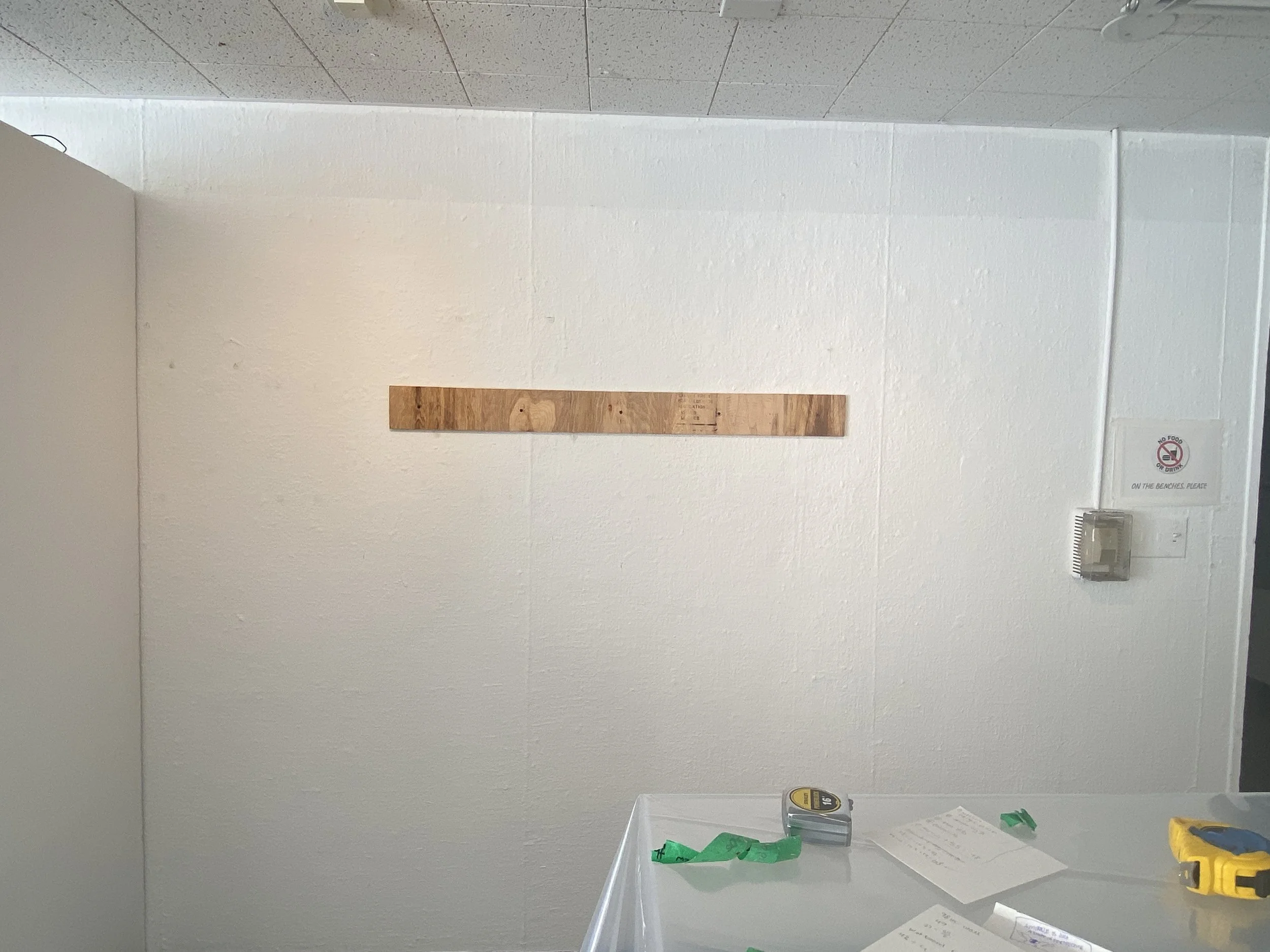 Drilled wall cleat into the wall of the gallery space for the display board to hang off of