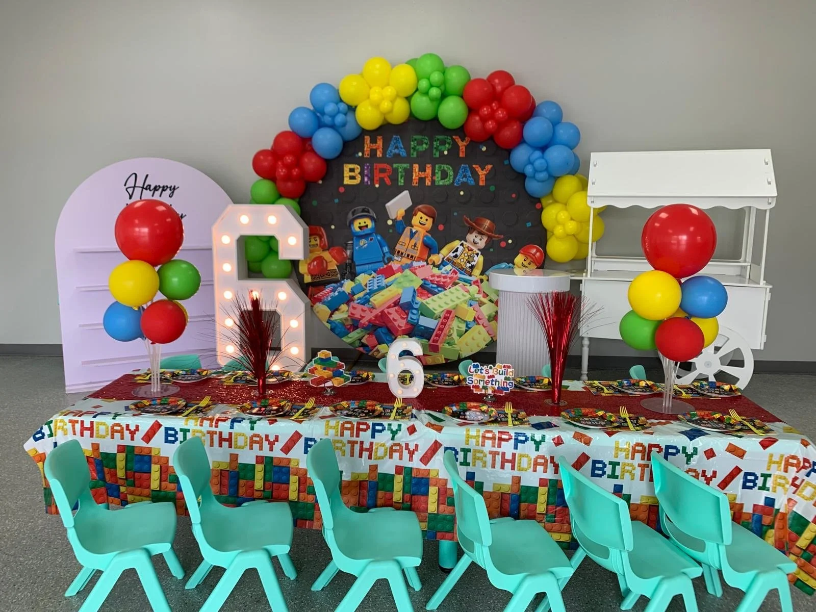Lego themed birthday with balloon arch, kids table settings and table decor