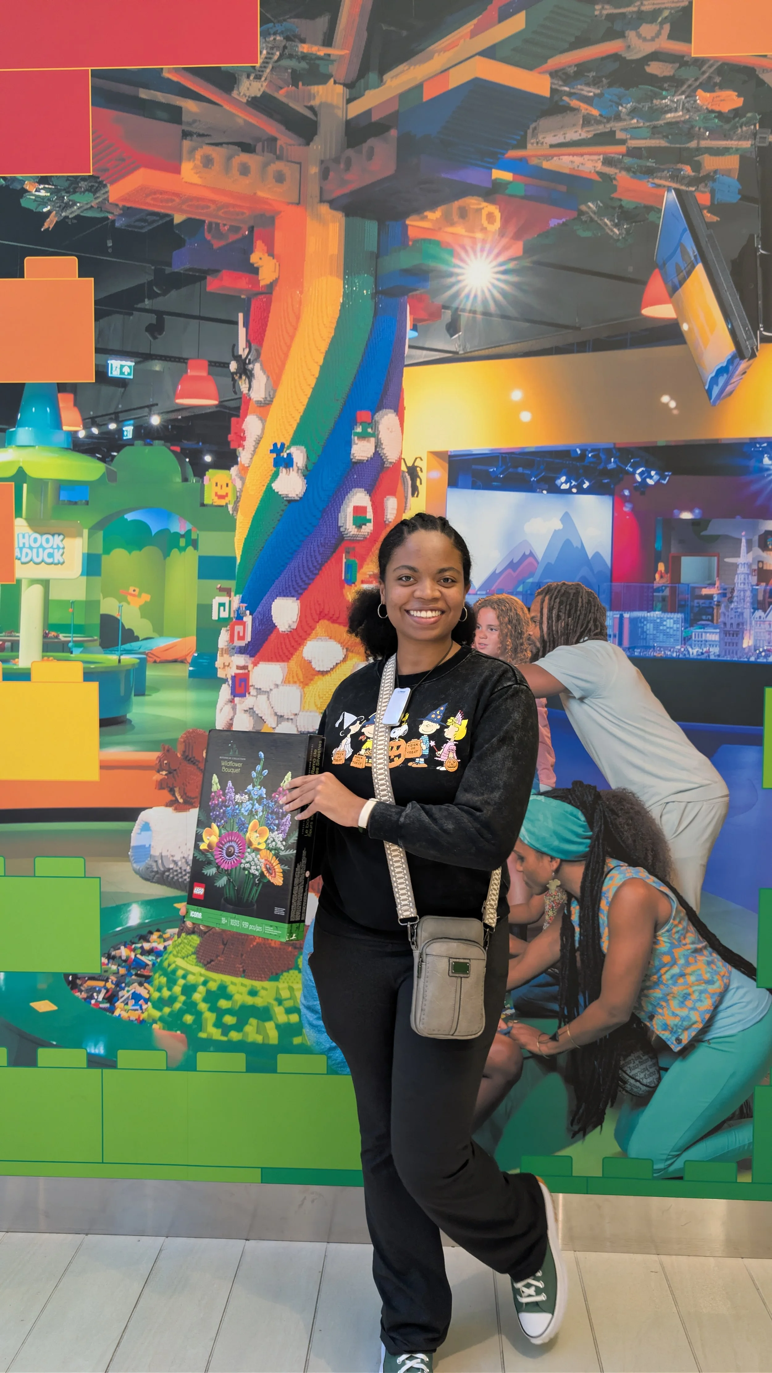 Black woman smiling with Legos at Lego Discovery Center