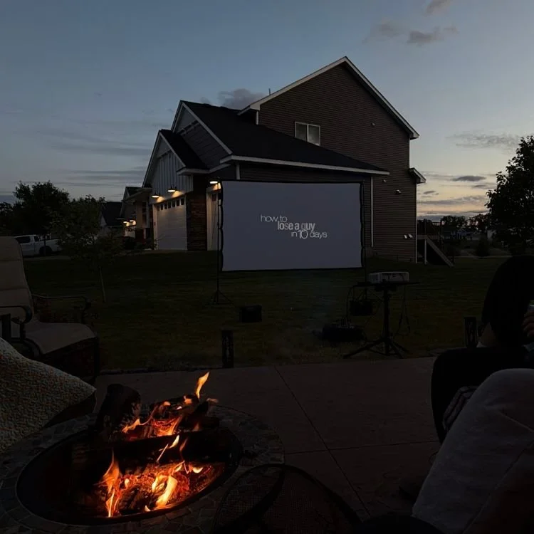 Outdoor movie on projector by a house.
