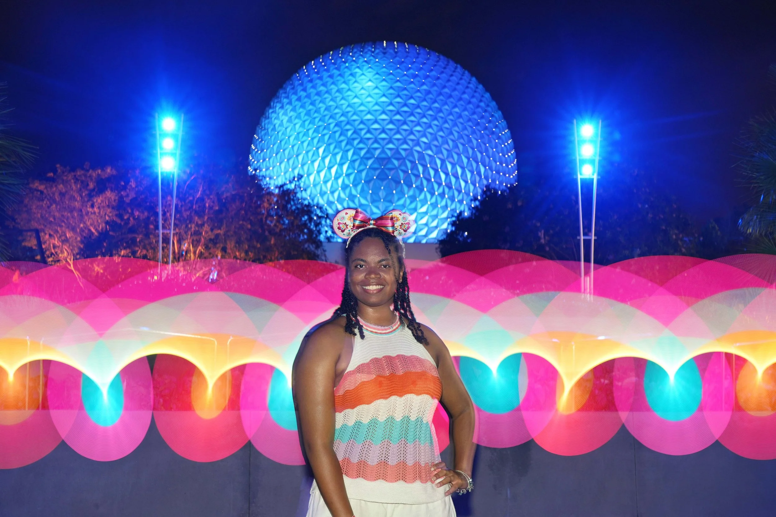 Black woman smiling in front of Epcot Ball.