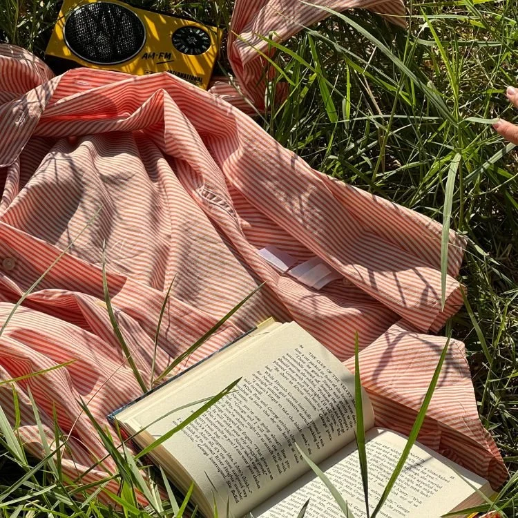 Book, radio, and shirt in the grass