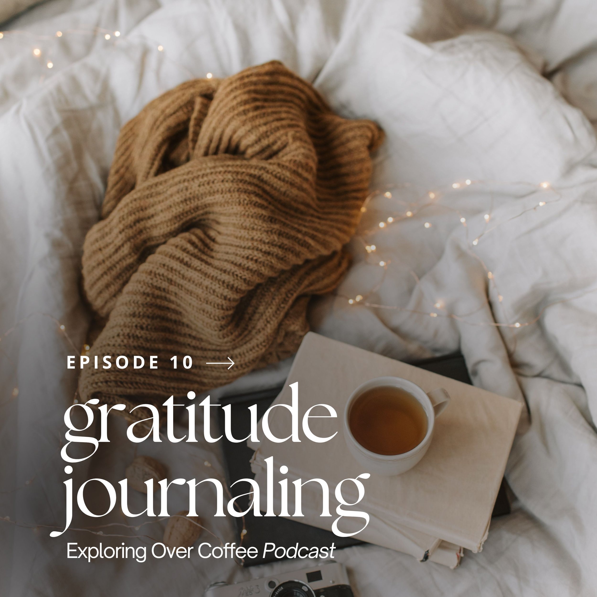 Stack of books, a cup of tea, a sweater, and fairy lights on a blanket