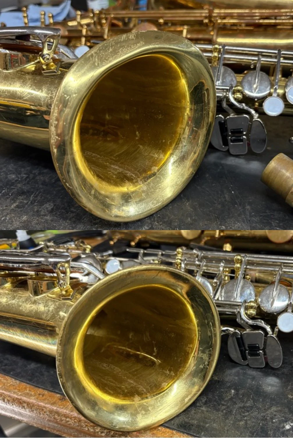 Close-up of the bell of a brass saxophone lying on a dark surface, with various other brass and wind instrument parts in the background. Before and after of saxophone dent repair.