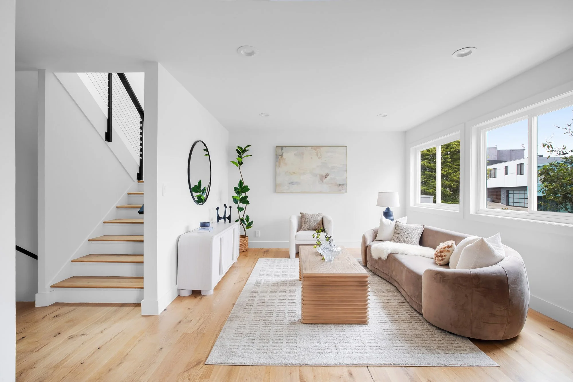 Living room at 75 Aloha Avenue in Golden Gate Heights, San Francisco, with refinished white oak floors, corner windows, and an open stair with cable railing.