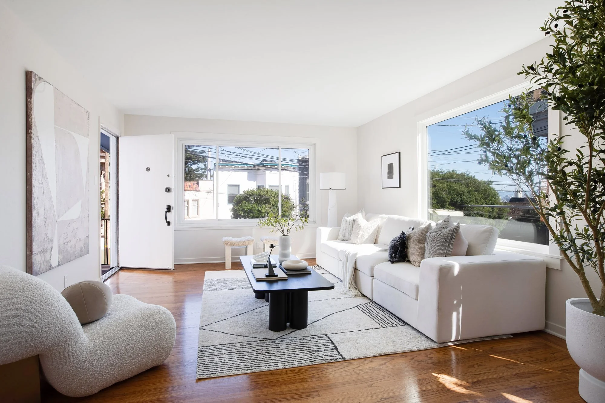 Living room at 465 30th Street with new windows on two walls, hardwood floors and treetop views toward downtown San Francisco