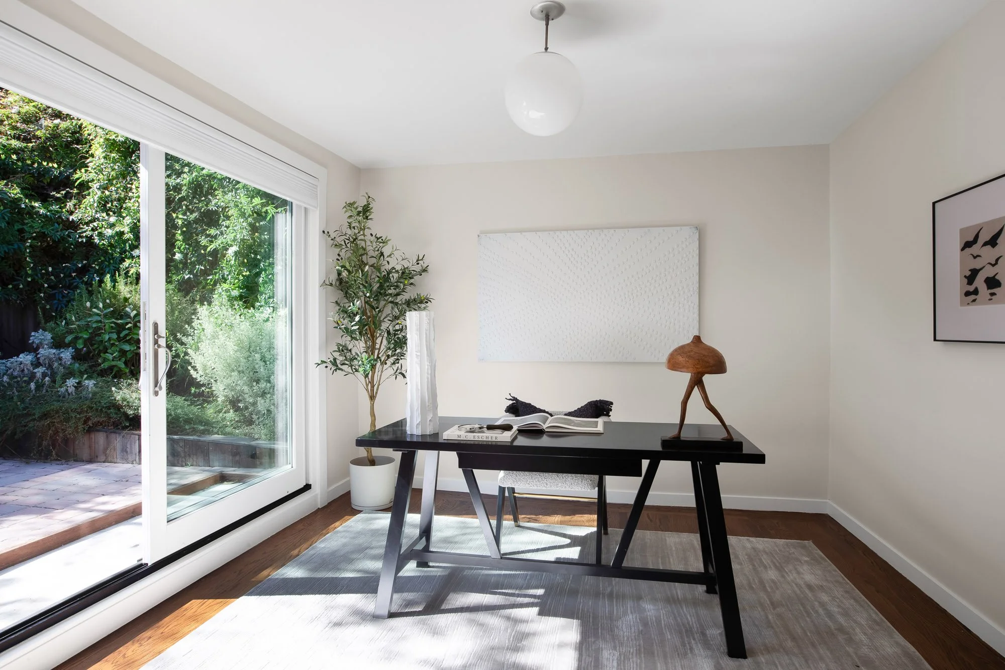 Second living area at 465 30th Street with a wide sliding glass door opening directly to the pavered patio and drought-tolerant garden