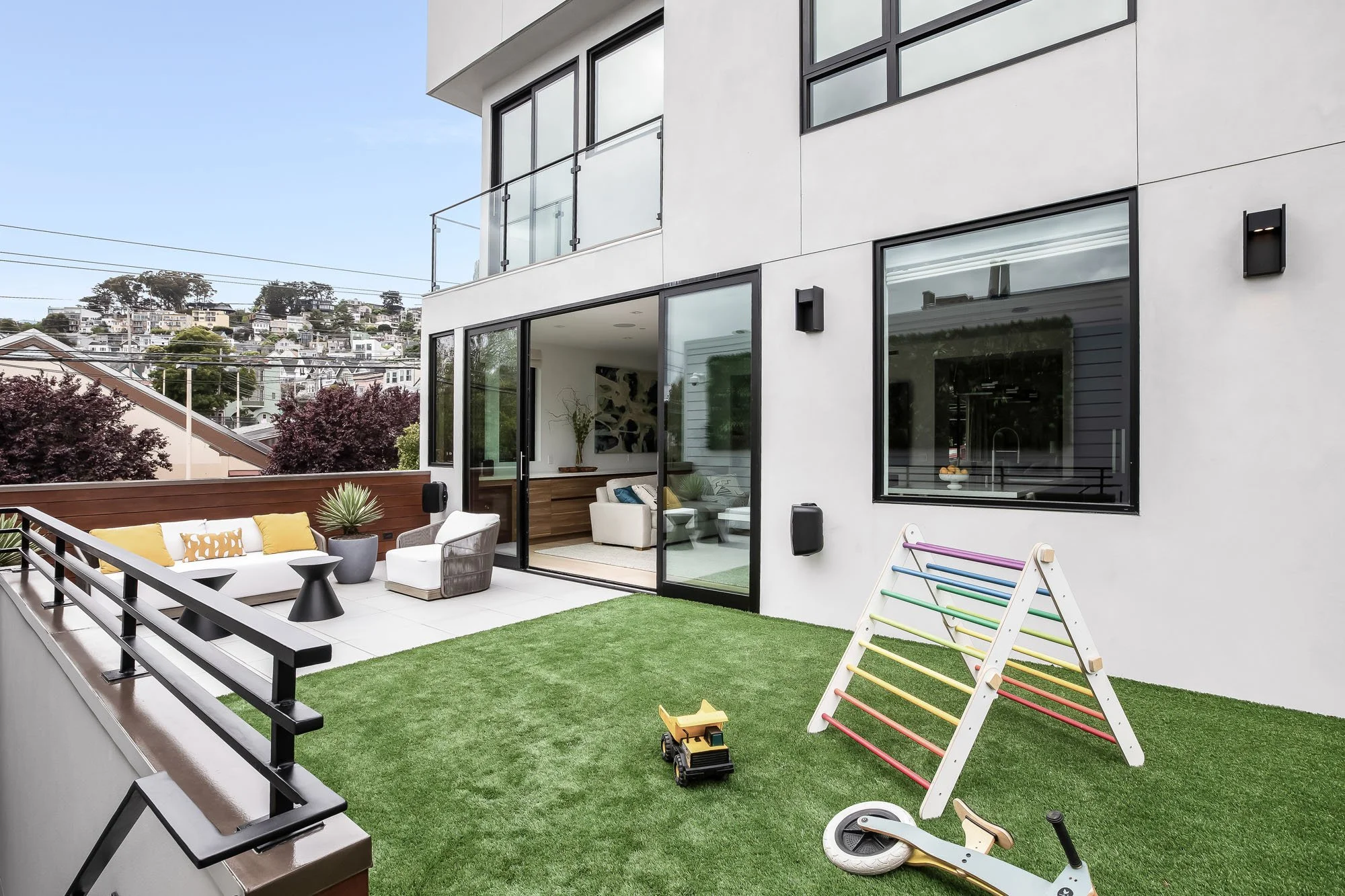 Family-friendly outdoor terrace at 1647 Sanchez in Noe Valley, showcasing seamless indoor-outdoor flow through large sliding glass doors.