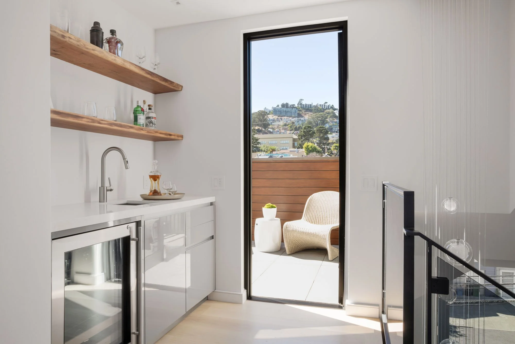 Designer wet bar at 1647 Sanchez featuring live-edge wood shelving, wine refrigeration, and a sun-drenched terrace with expansive San Francisco views.