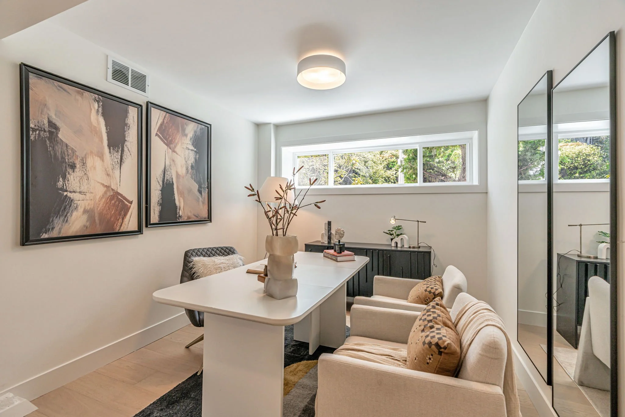 Professional San Francisco home office featuring abstract wall art, floor-to-ceiling mirrors, and a minimalist desk setup perfect for an at-home professional.