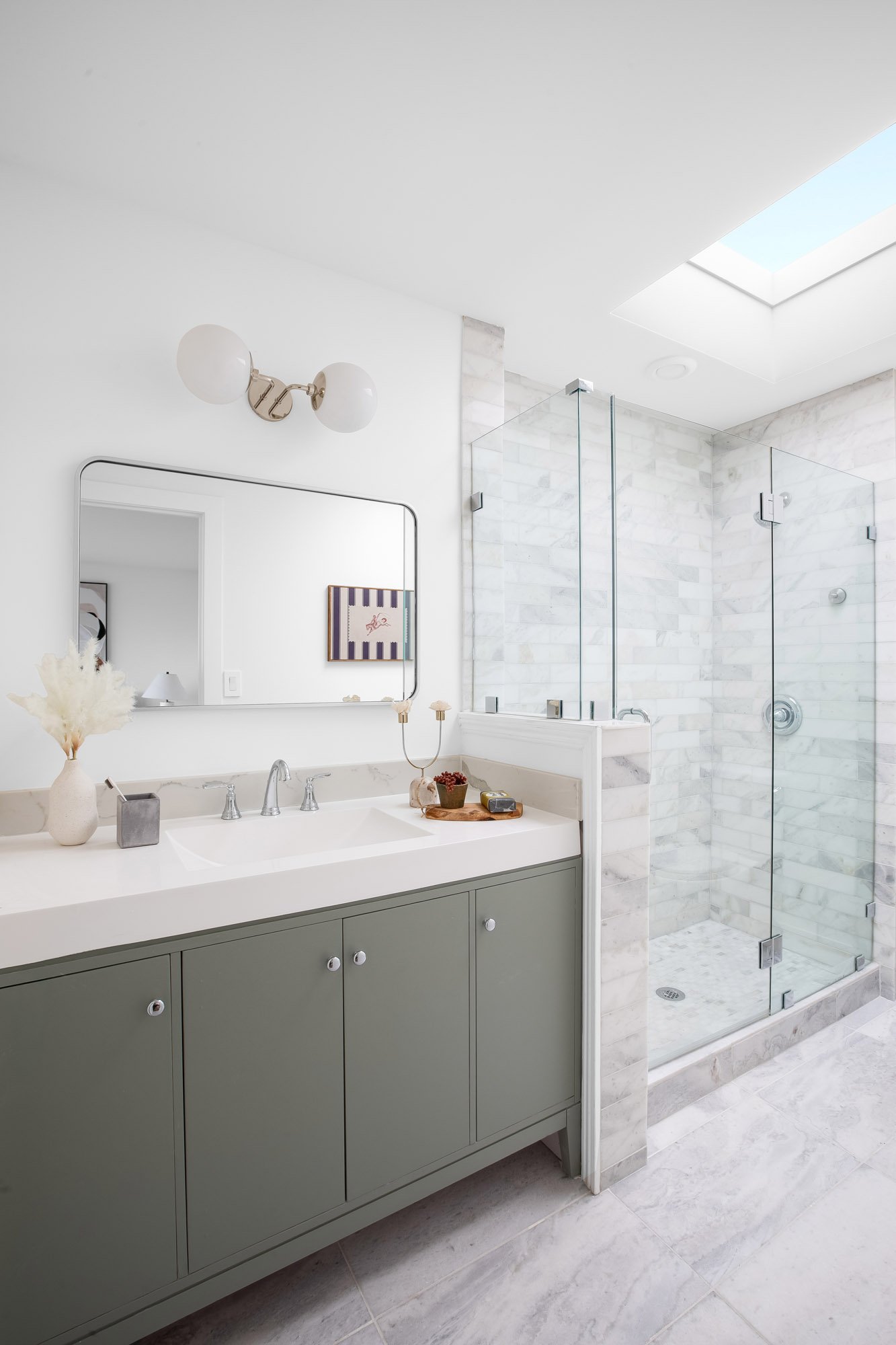 Updated primary ensuite at 75 Aloha Avenue in Golden Gate Heights, San Francisco, with a green vanity, marble-tiled glass shower, and a skylight above.