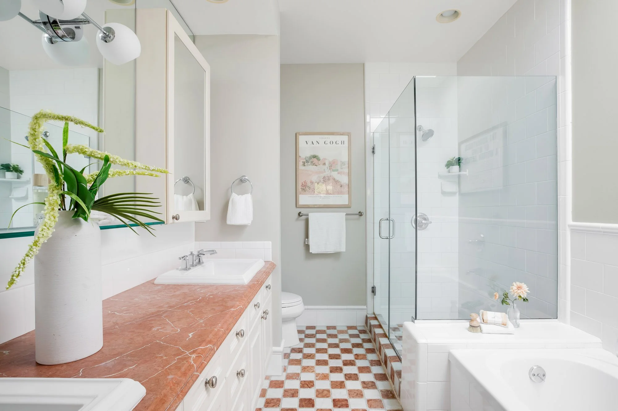 Primary en suite bathroom at 2172 Fell Street San Francisco with rose marble countertop, double undermount sinks, glass-enclosed walk-in shower, separate soaking tub, and terracotta checkerboard tile floor